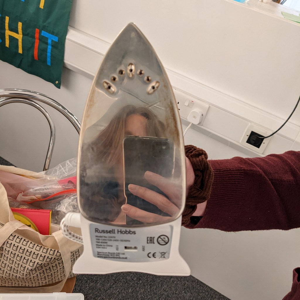 Iron with marks on to top left and right. 